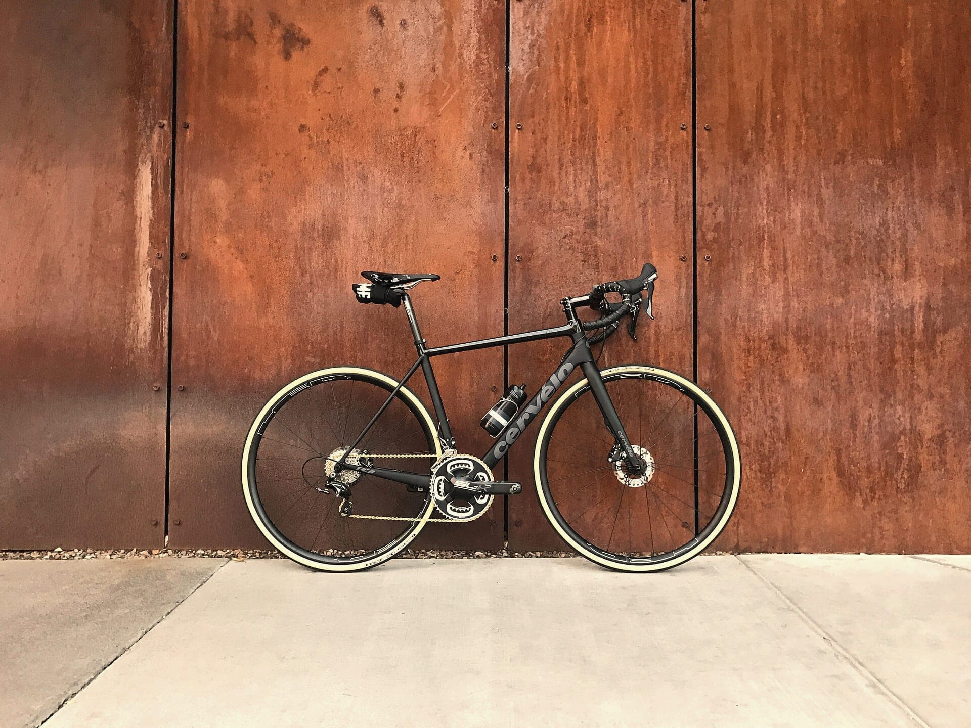 A road bicycle against a rust-coloured wall