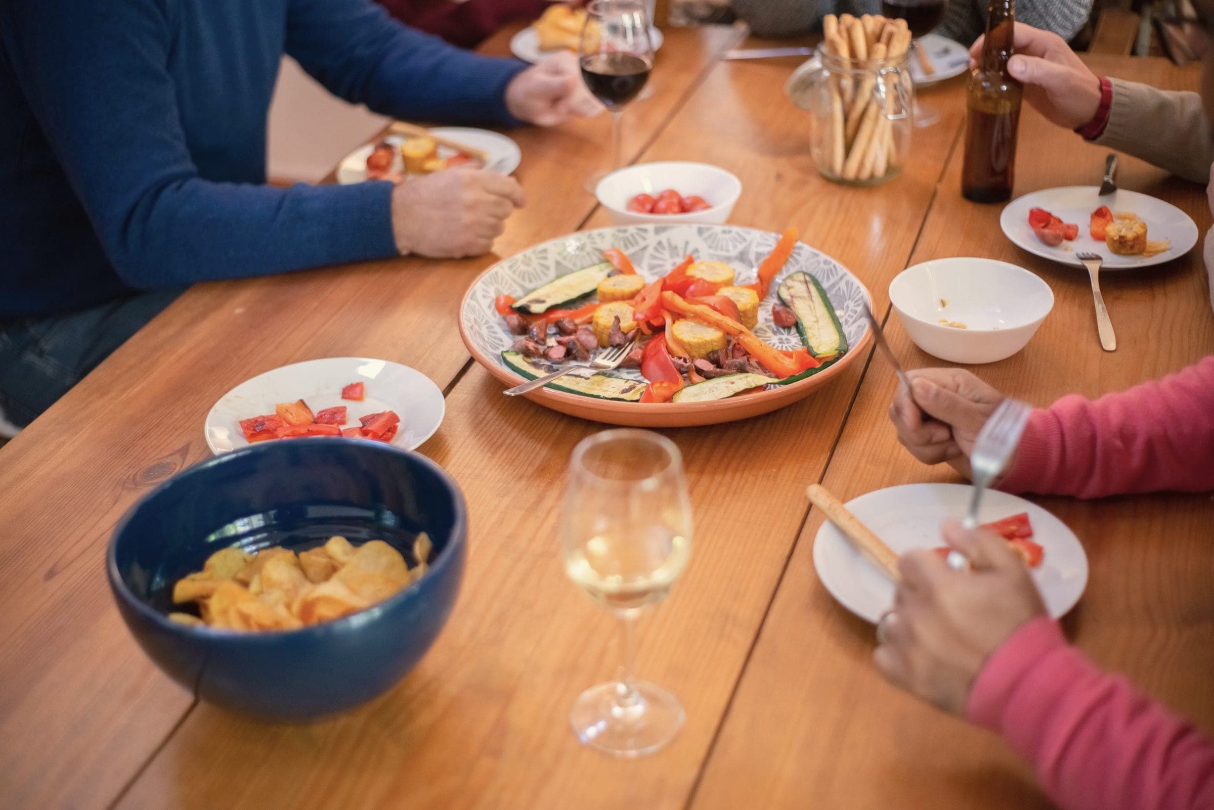 Friends sharing food and wine around a wooden table