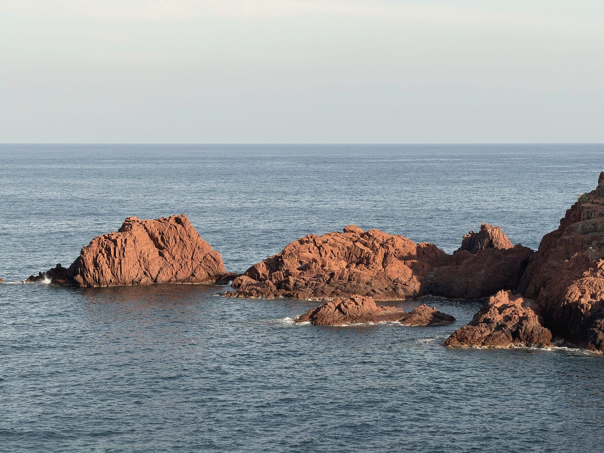 Red porphyry rocks of the Esterel in a calm sea